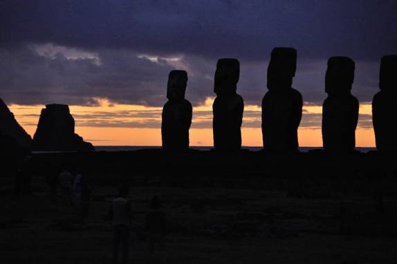 Turistas assitem ao nascer-do-sol atrás da fileira de Moais de Tongariki, no sul da Ilha de Páscoa, ilha chilena no meio do Oceano Pacífico